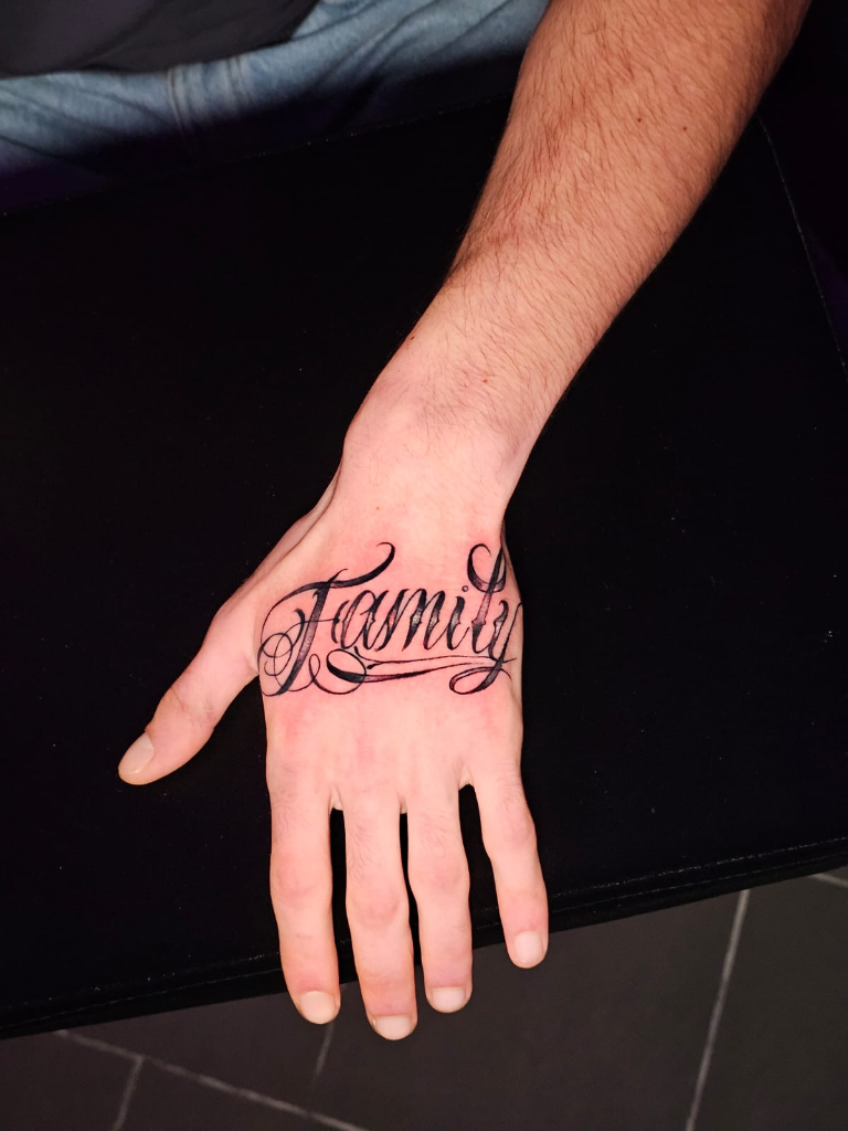 Family Lettering Tattoo auf der Hand - Fine Line Tattoo Reims